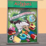 L’entrata della sede di Alfabeti in via Abbiati, con il nuovo affresco dipinto direttamente sulla serranda.